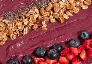 A close up of an acai spread with granola and berries